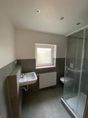 een badkamer met een wastafel en een douche bij OWL Comfort Homes - Monteurwohnung/ Handwerkerunterkunft in Porta Westfalica