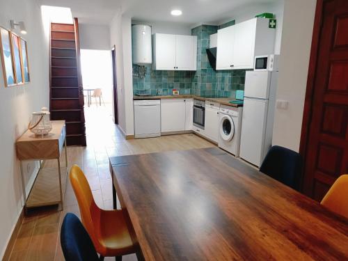 a kitchen with a wooden table and a dining room at Apartamento Praia da Gale in Albufeira
