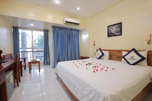 a bedroom with a large bed with roses on it at Khách Sạn Hạnh Long in Ho Chi Minh City