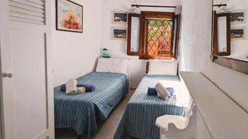 コスタ・コラッリナにあるCasa vacanze a Costa Corallinaの窓付きの小さな部屋のベッド2台