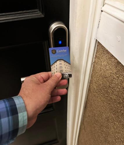 a person unlocking a door with a card on it at Castelar Hotel Santa Fe in Santa Fe