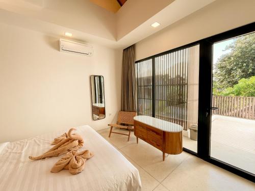 スミニャックにあるVilla Prada II 3BR Villa Near to Beach in Seminyakのベッドルーム1室(ベッド1台付)が備わります。バルコニーの景色を望めます。
