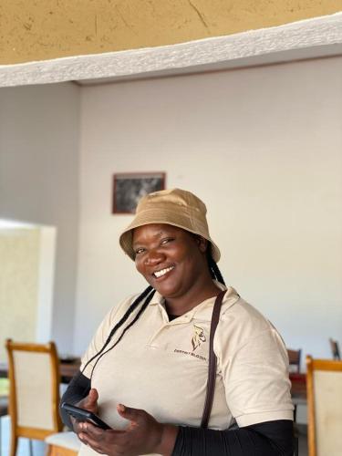 a pregnant woman wearing a hat holding a cell phone at Destiny Blo Inn in Kachikau