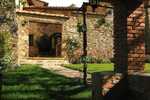 un bâtiment en pierre avec un chemin dans une cour dans l'établissement Romantisches Apartment für Paare mit Terrasse und Blick auf den Garten, à San Donato in Poggio