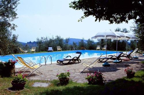 - une piscine avec des chaises longues et un parasol dans l'établissement Romantisches Apartment für Paare mit Terrasse und Blick auf den Garten, à San Donato in Poggio