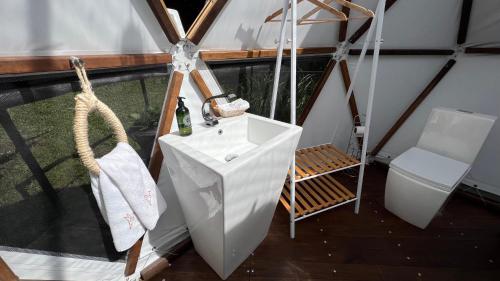 - une salle de bains dans un dôme avec un lavabo et une chaise dans l'établissement Casa Quincha Glamping, à San Francisco