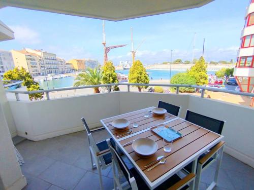 une table sur un balcon avec vue sur un port dans l'établissement Charmant T2 neuf climatisé, vue sur les quais, à Sète