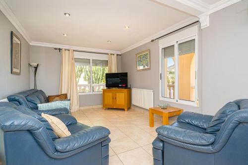 uma sala de estar com dois sofás azuis e uma televisão em Felderhof Villa 4 bed Private Pool em Busot