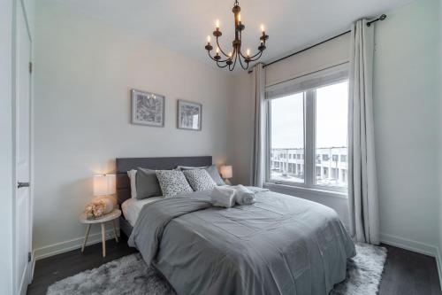 Un dormitorio con una cama y una ventana grande. en Luxury Urban Town home, en Oakville