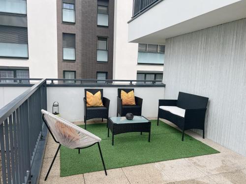 a patio with chairs and a hammock on a balcony at Appart Charme Contemporain et Balcon Verdoyant à Bois-Colombes in Bois-Colombes