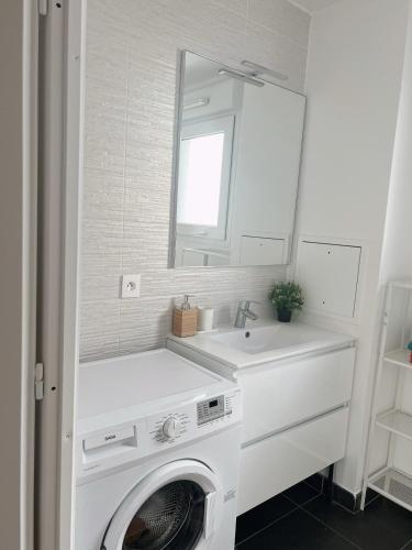 une salle de bain avec une machine à laver et un lavabo dans l'établissement Appart Charme Contemporain et Balcon Verdoyant à Bois-Colombes, à Bois-Colombes