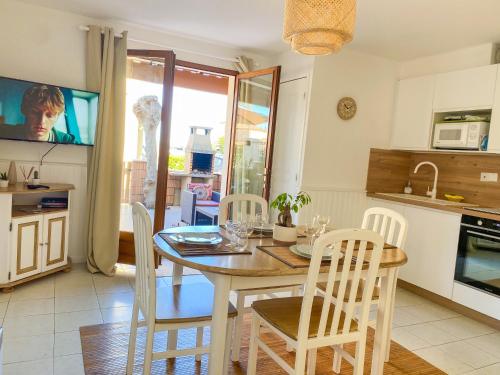 une cuisine et une salle à manger avec une table et des chaises dans l'établissement Dydy Haven - maison de vacances à Vias plage, piscine, mer et climatisation, à Vias