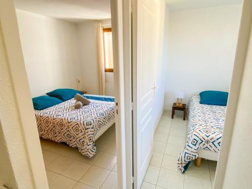 - une petite chambre avec 2 lits et une porte dans l'établissement Dydy Haven - maison de vacances à Vias plage, piscine, mer et climatisation, à Vias