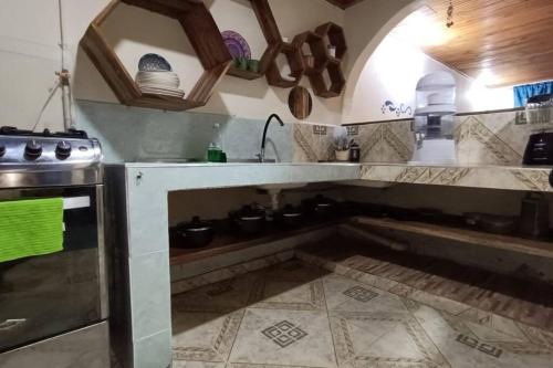 eine Küche mit einer Theke mit Töpfen und Pfannen in der Unterkunft Casa Rio de Cristal in Pijao