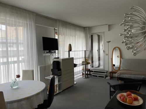 a living room with a table and a television and a room at Big apartment with terrace & central location in Paris