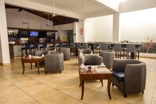 a restaurant with tables and chairs and a bar at Casa Andina Select Zorritos Tumbes in Zorritos