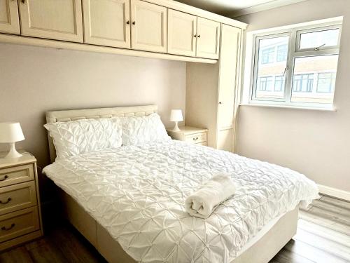 a white bed with a towel on it in a bedroom at StayViva - Spacoius 3 BR House - Garden, Games Room, Parking near Town Centre and Train station in Bracknell