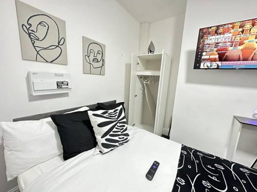 a bedroom with a bed with a remote control on it at Cosy Chic Flat in the Heart of Kidderminster in Kidderminster