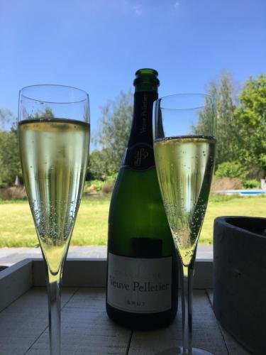 zwei Gläser Champagner neben einer Flasche Wein in der Unterkunft Slapen bij de Stewardess B&B Almere in Almere