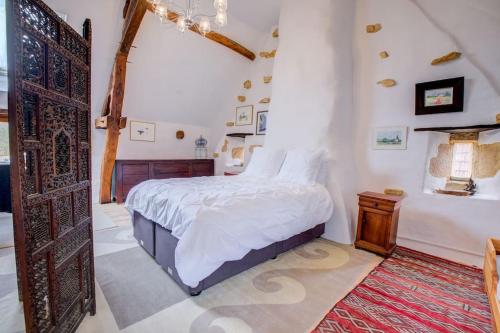 a bedroom with a bed and a wooden door at l'Escarpediem : Évasion Pittoresque in Meyrals