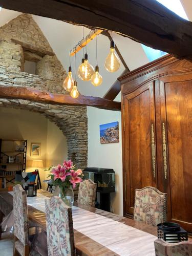 une salle à manger avec une table et une cheminée en pierre dans l'établissement Chambres d'hôtes Escapade Bretonne, à Lannion