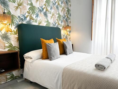 a bedroom with a large bed with orange pillows at La Casa de Carmen in Castilleja de la Cuesta