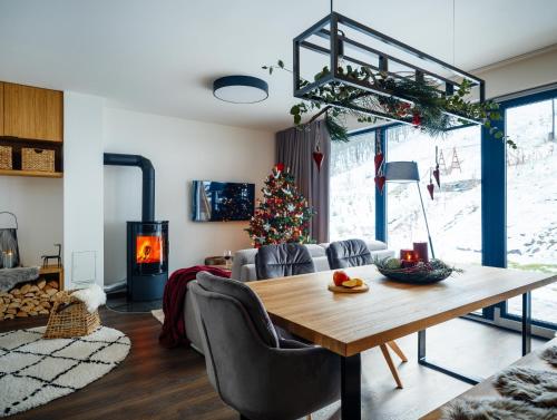 a living room with a table and a christmas tree at Apartmán Prkenný důl in Prkenný Dŭl