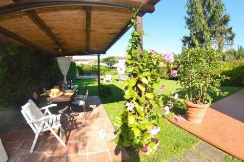 un patio con mesa, sillas y flores en Ferienhaus mit Privatpool für 2 Personen ca 65 qm in Capannori, Toskana Provinz Lucca, en Capannori