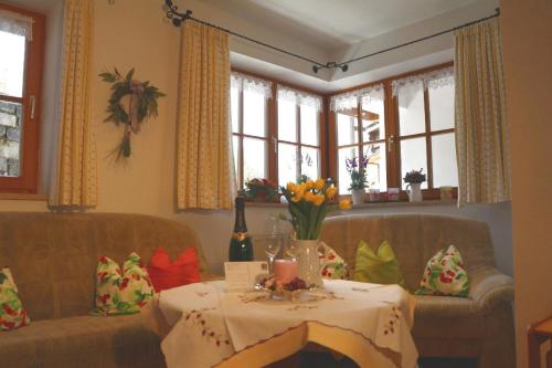 a living room with a table and two couches and windows at Große Wohnung in Berchtesgaden mit Terrasse und Garten in Berchtesgaden