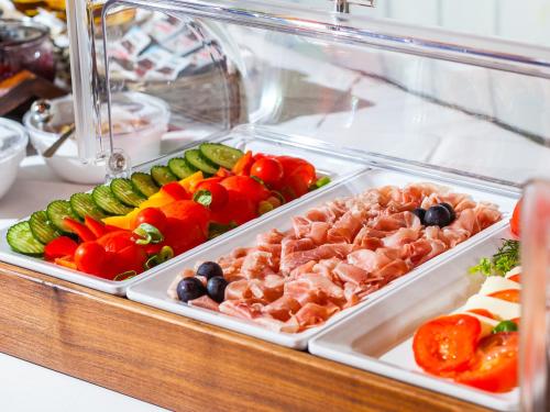 een vitrine gevuld met verschillende soorten fruit en groenten bij Ahauser Landhotel in Alstätte