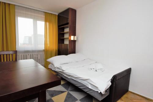 a bed in a room with a desk and a table at roomspoznan pl - Powstancow Wielkopolskich 23 - 24h self check-in in Poznań