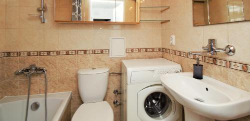 a bathroom with a washing machine and a sink at roomspoznan pl - Powstancow Wielkopolskich 23 - 24h self check-in in Poznań