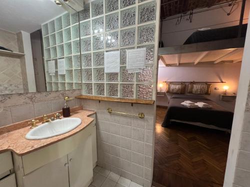 ein Bad mit einem Waschbecken und ein Bett in einem Zimmer in der Unterkunft Centro de Buenos Aires in Buenos Aires
