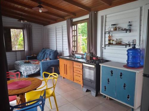 a kitchen with a stove and a table in a room at Hygge Sunset House in Ilha do Mel