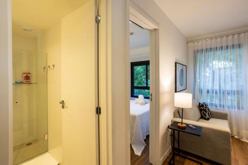 a bedroom with a bed and a shower and a window at Boulevard Ibirapuera in São Paulo