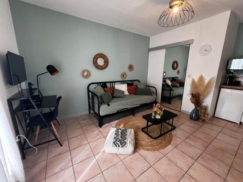 un salon avec un canapé et une table dans l'établissement Aix-en-Provence, Charmant studio proche toutes comodités et axes routiers, linges fournis, à Aix-en-Provence