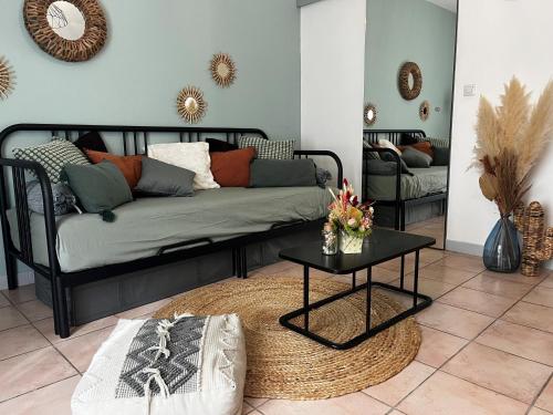 un salon avec un canapé et une table dans l'établissement Aix-en-Provence, Charmant studio proche toutes comodités et axes routiers, linges fournis, à Aix-en-Provence