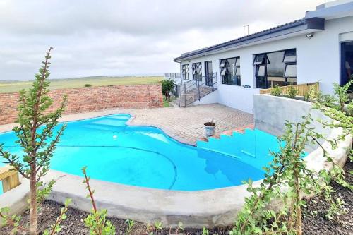 an image of a swimming pool in front of a house at The Farmstead in Cannon Rocks