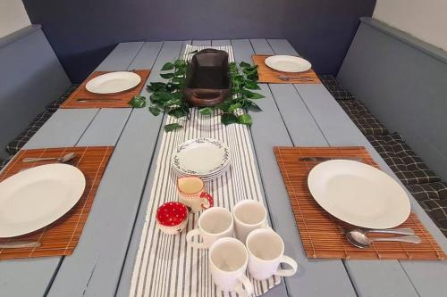 a table with plates and cups and utensils at The Farmstead in Cannon Rocks