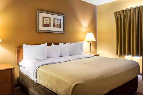 Habitación de hotel con cama grande con almohadas blancas en Extended Stay America Suites - Lancaster County, en Mountville