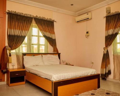 a bedroom with a bed and a large window at Cozy 2 bedroom serviced Apartment in Calabar