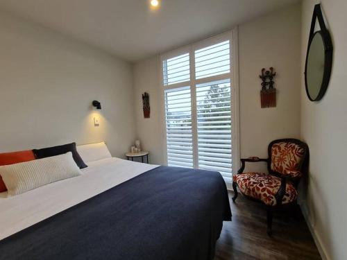 sypialnia z łóżkiem, krzesłem i oknem w obiekcie Stunning Views, 2 Bedroom 2 minutes to town centre w mieście Queenstown