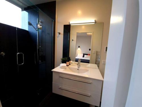 W łazience znajduje się umywalka, prysznic i lustro. w obiekcie Stunning Views, 2 Bedroom 2 minutes to town centre w mieście Queenstown