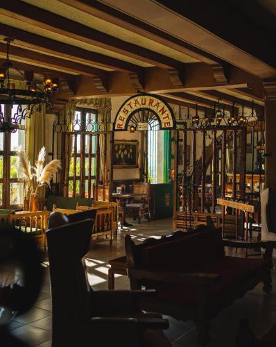 a room with chairs and tables and windows at Hotel Posada la Ermita in San Miguel de Allende