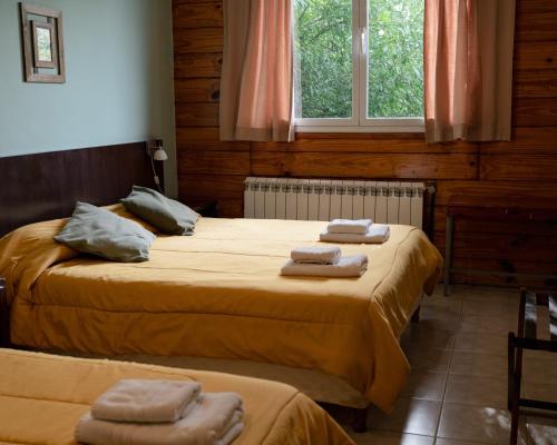 2 łóżka w pokoju z ręcznikami w obiekcie Folk Suites w mieście El Calafate