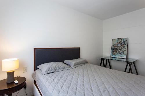 a bedroom with a bed and a table with a lamp at Menara Morumbi in Sao Paulo