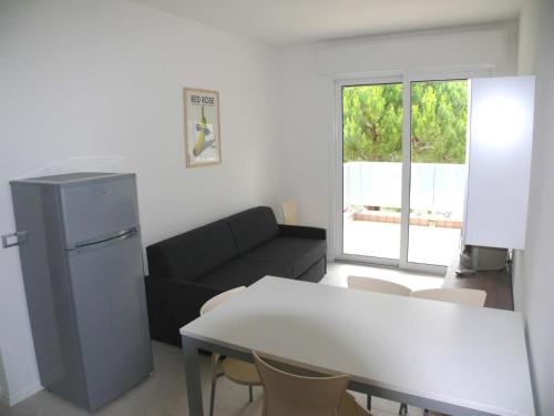 sala de estar con sofá negro y mesa en Ferienwohnung für 6 Personen ca 45 qm in Bibione, Adriaküste Italien Bibione und Umgebung - b63277, en Bibione