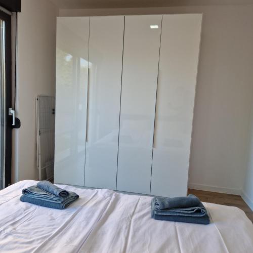 a bedroom with a bed with two blue towels on it at Apartmani Relaxsea in Privlaka