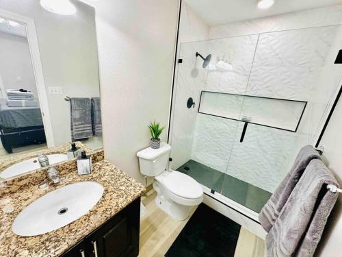 a bathroom with a toilet and a sink and a shower at Sharyland Townhome in McAllen