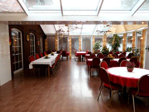a dining room with tables and red chairs at Hotel-Garni Herzog in Loher Ostmark